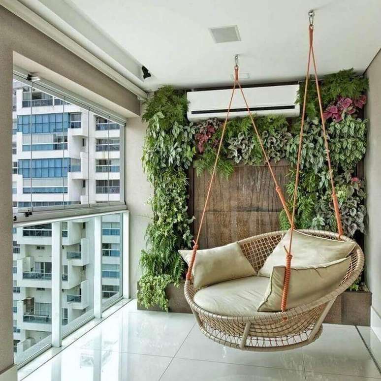 1. Cadeira de balanço suspensa para varanda de apartamento decorada com jardim vertical – Foto: Pinterest
