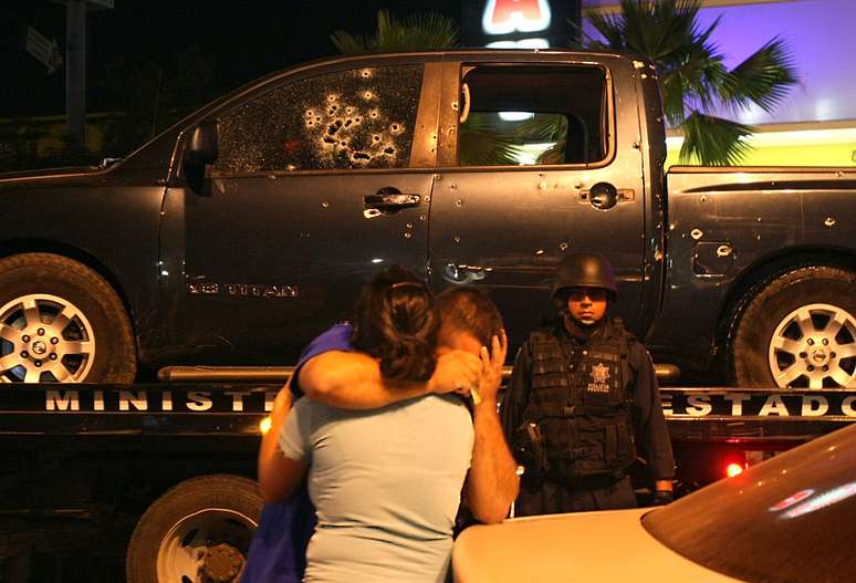 Um policial é consolado pela esposa após um tiroteio com narcotraficantes, em Culiacán, em que vários policiais morreram
