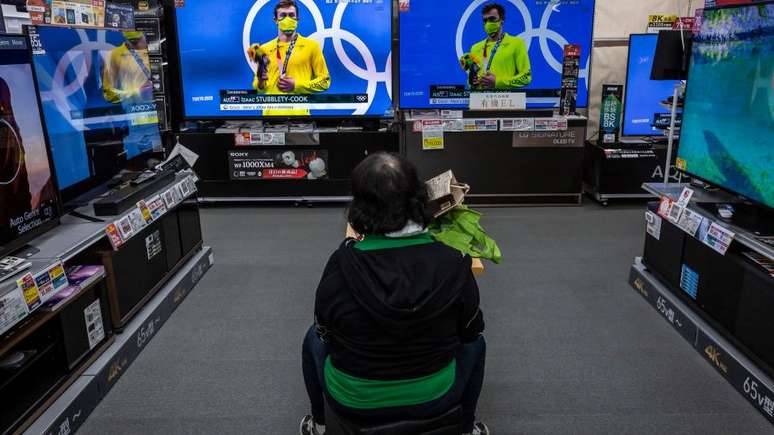 As pessoas estão sendo incentivadas a ficar em casa e assistir às Olimpíadas na televisão