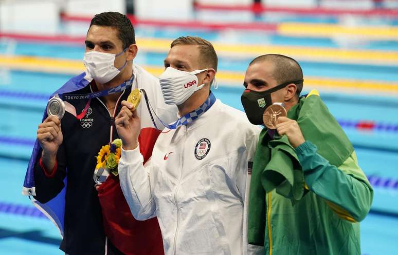 Bruno Fratus exibe a sua medalha de bronze ao lado de Dressel (ouro) e Manadou (prata)