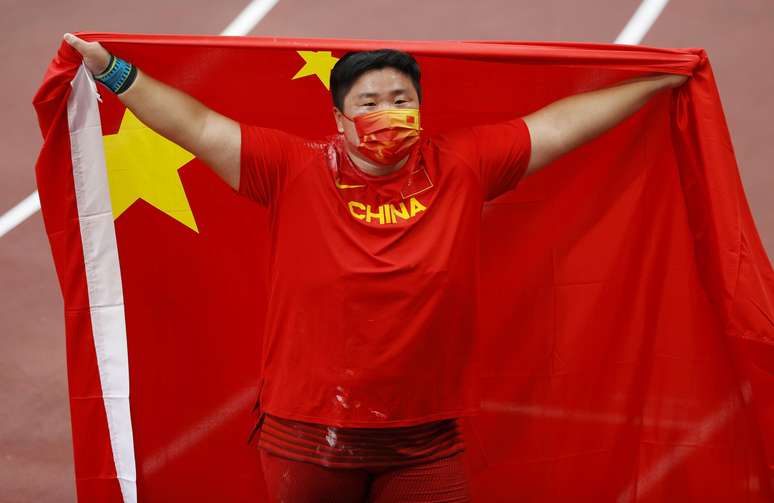 Gong Lijiao of China comemora a medalha de ouro com a bandeira da China Phil Noble Reuters