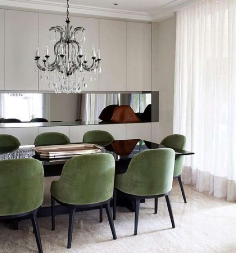 42. Decoração de sala de jantar com lustre de cristal e cadeira verde musgo – Foto: Jeito de Casa