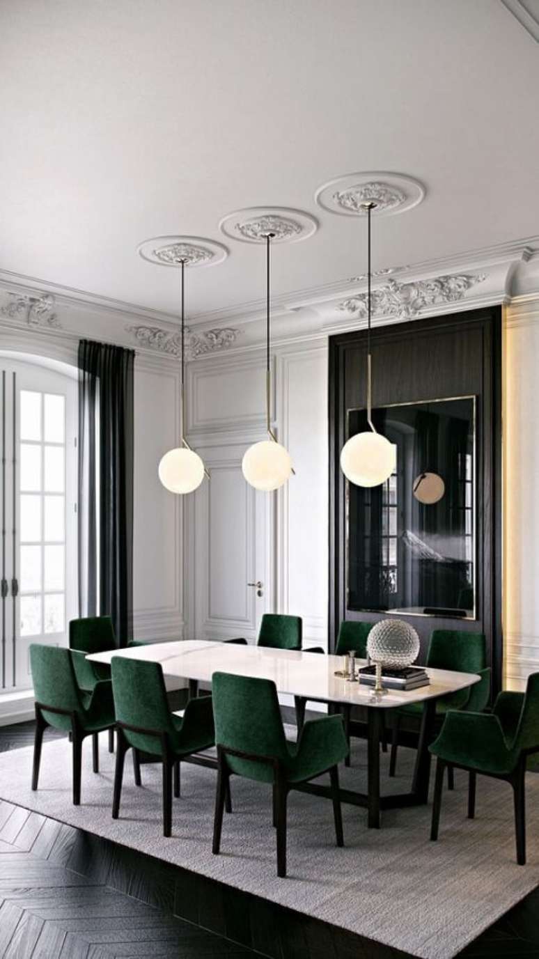 44. Decoração de sala de jantar sofisticada com luminária moderna e cadeira verde escuro – Foto: Apartment Therapy