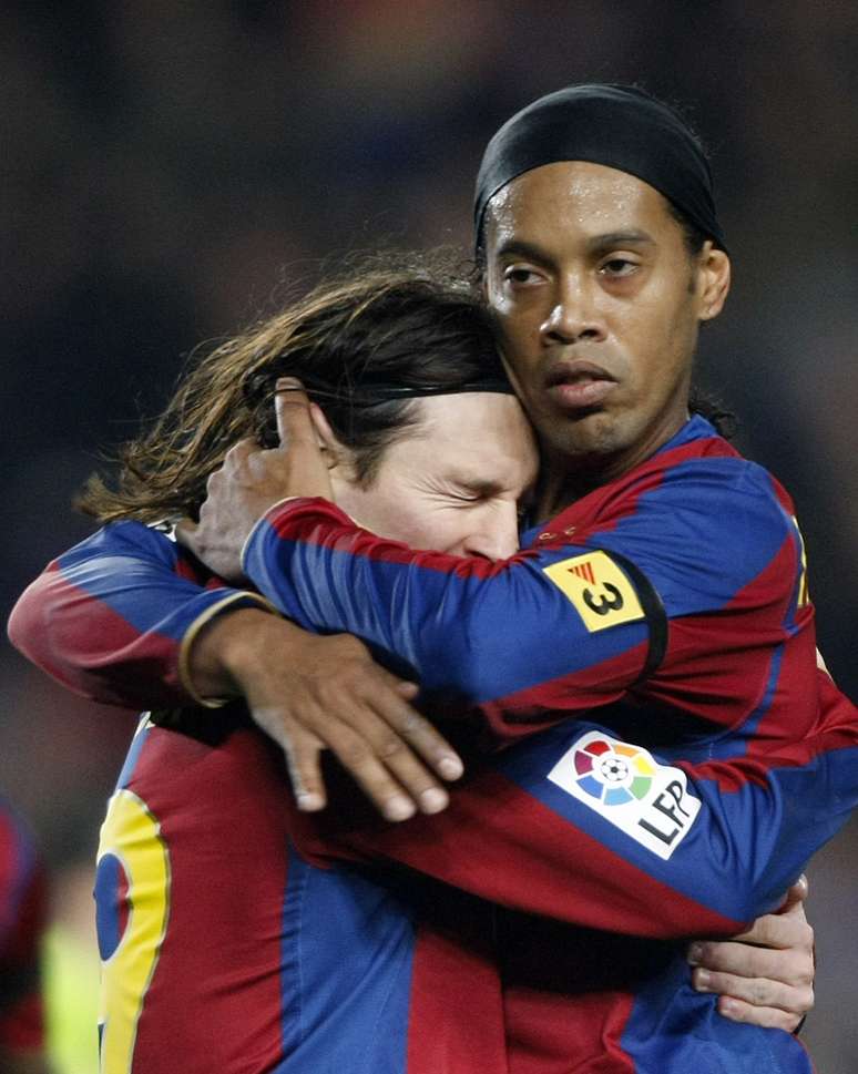 Ronaldinho abraça Messi na época em que defendiam o Barcelona