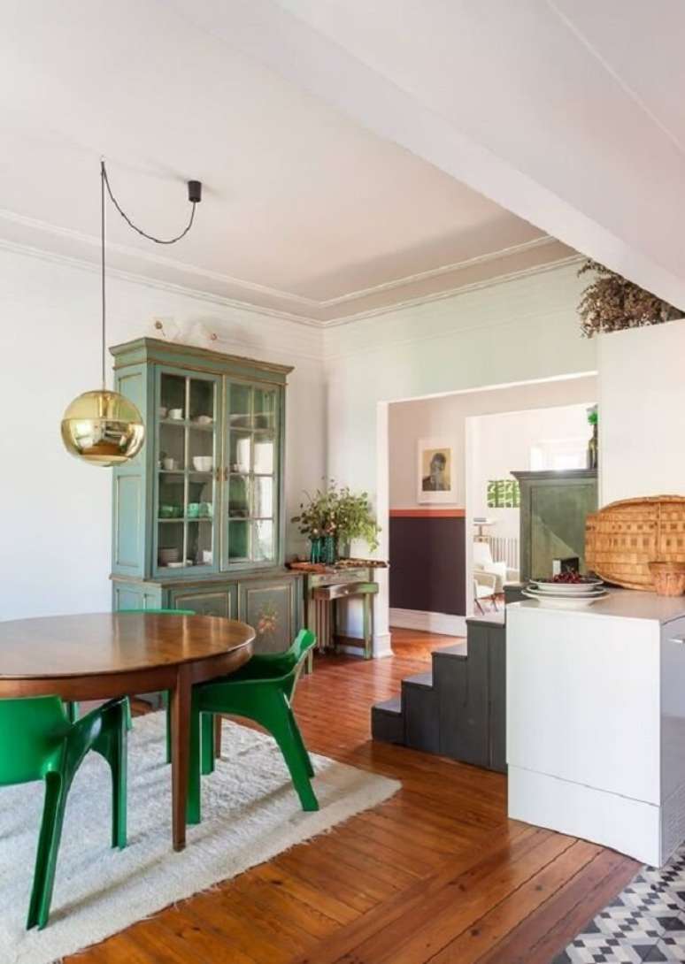 26. Cadeira verde moderna para sala de jantar decorada com mesa de madeira e luminária redonda – Foto: Histórias de Casa