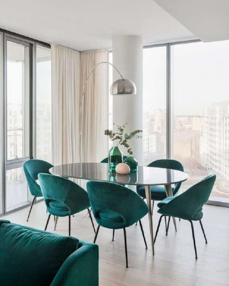 37. Decoração clean para sala de jantar com mesa oval preta e cadeira estofada verde – Foto: Curated Interior