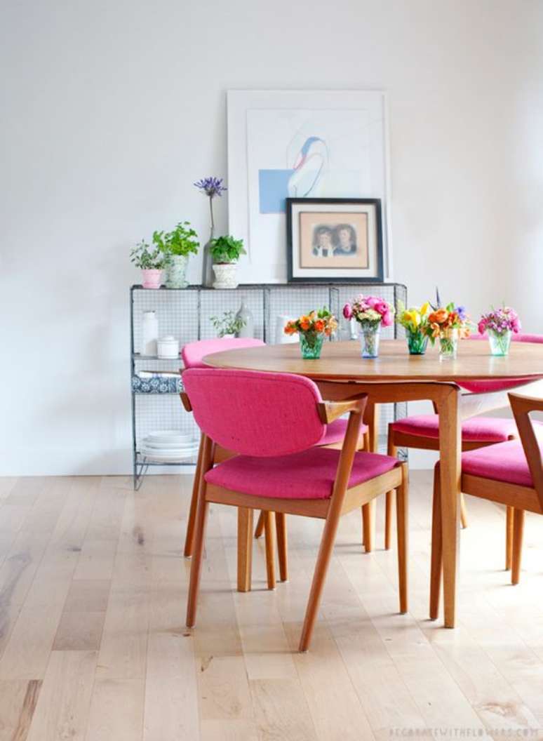 9. Sala de jantar com mesa retrô de madeira e cadeiras rosa – Foto A casa que minha vó queria