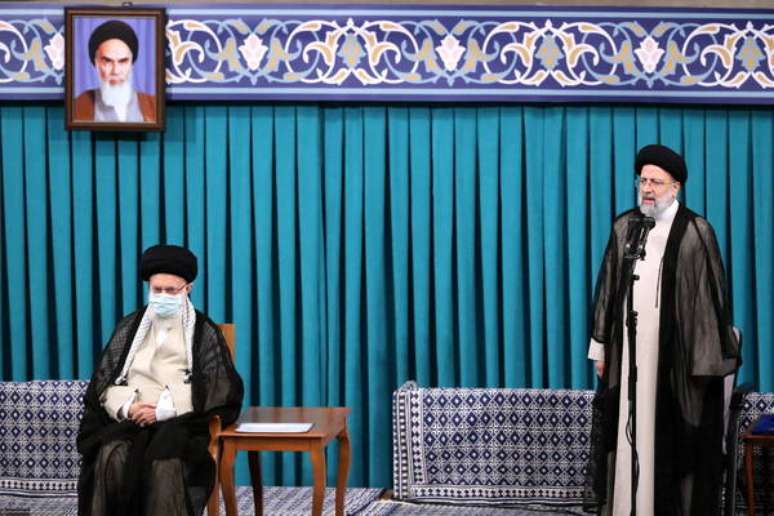 Guia supremo Ali Khamenei (sentado) ouve discurso de posse de Ebrahim Raisi