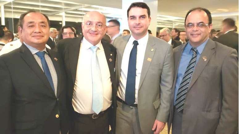 Gomes de Paula (gravata listrada) aparece ao lado de Flávio Bolsonaro em foto compartilhada no Facebook da ONG em foto publicada em 2019