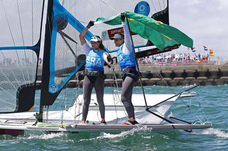 Martine Grael e Kahena Kunze comemoram ouro carregando a bandeira do Brasil Ivan Alvarado/Reuters