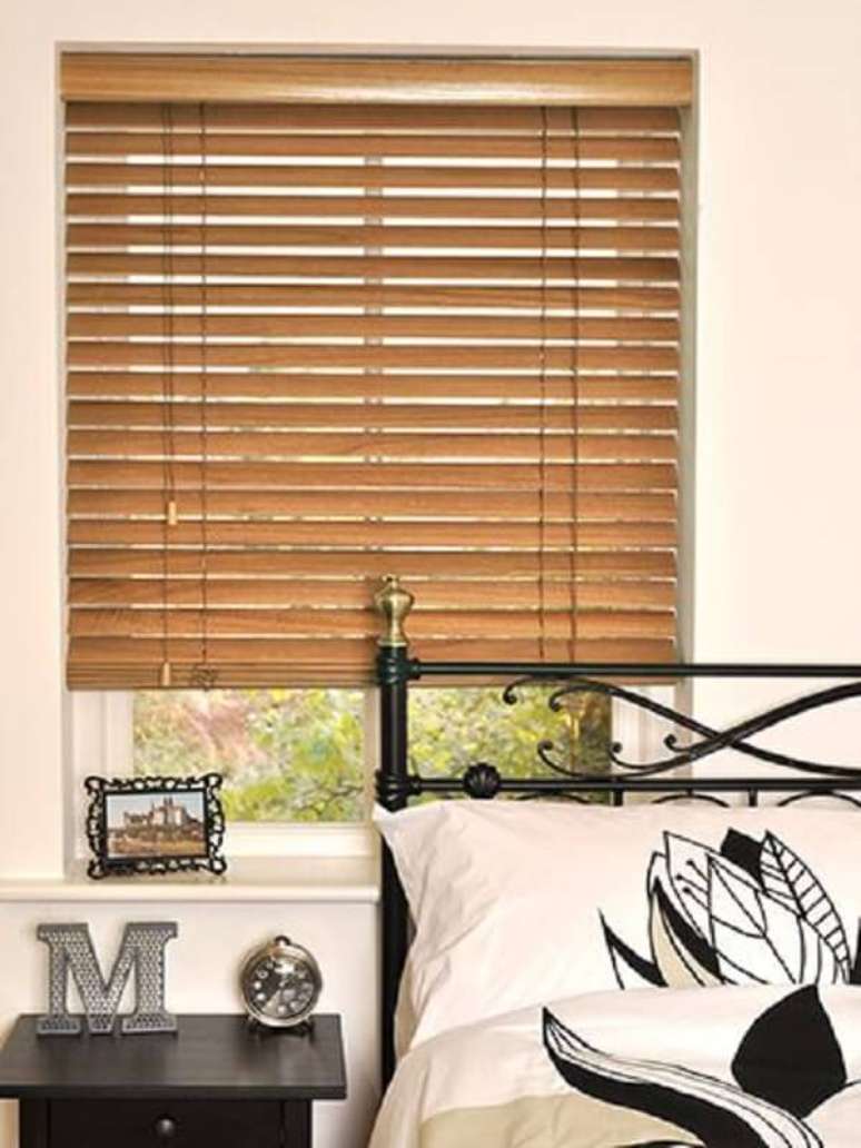 32. Cama de ferro e persiana de madeira para a decoração do quarto. Fonte: Pinterest