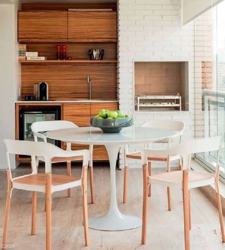 50. Mesa redonda para decoração de apartamento com varanda gourmet e churrasqueira – Foto: Arquitrecos