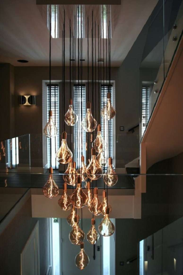 44. É difícil não se encantar pelos filamentos das lâmpadas desse lustre para escada. Fonte: Pinterest