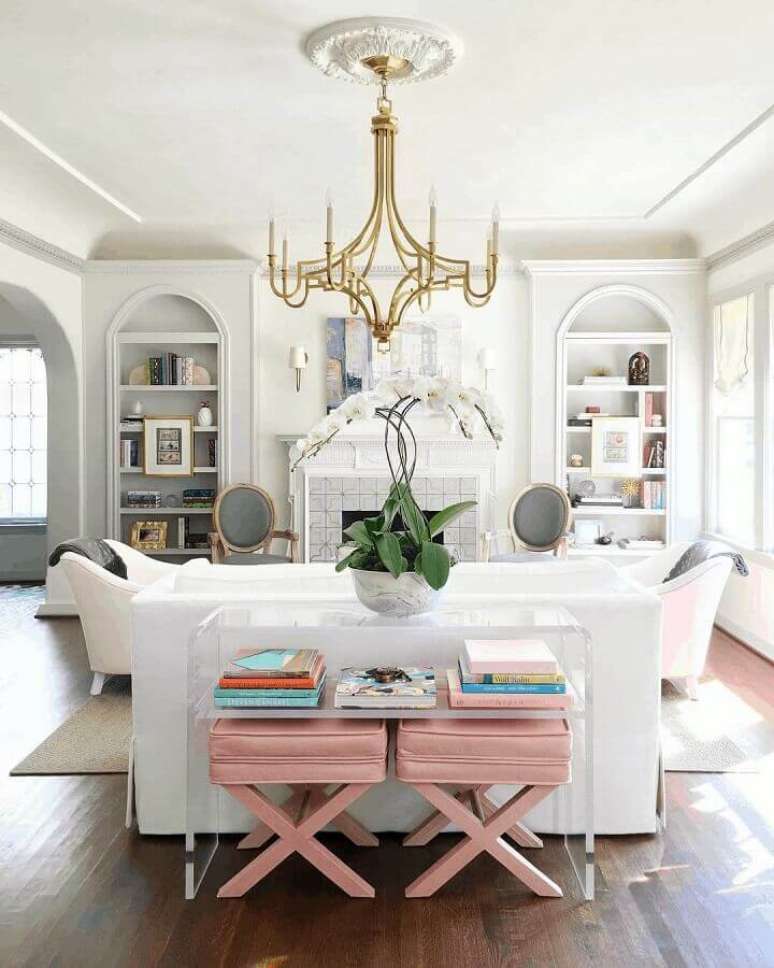 15. Decoração clássica para sala branca com banqueta puff rosa claro – Foto: Catherine French Design