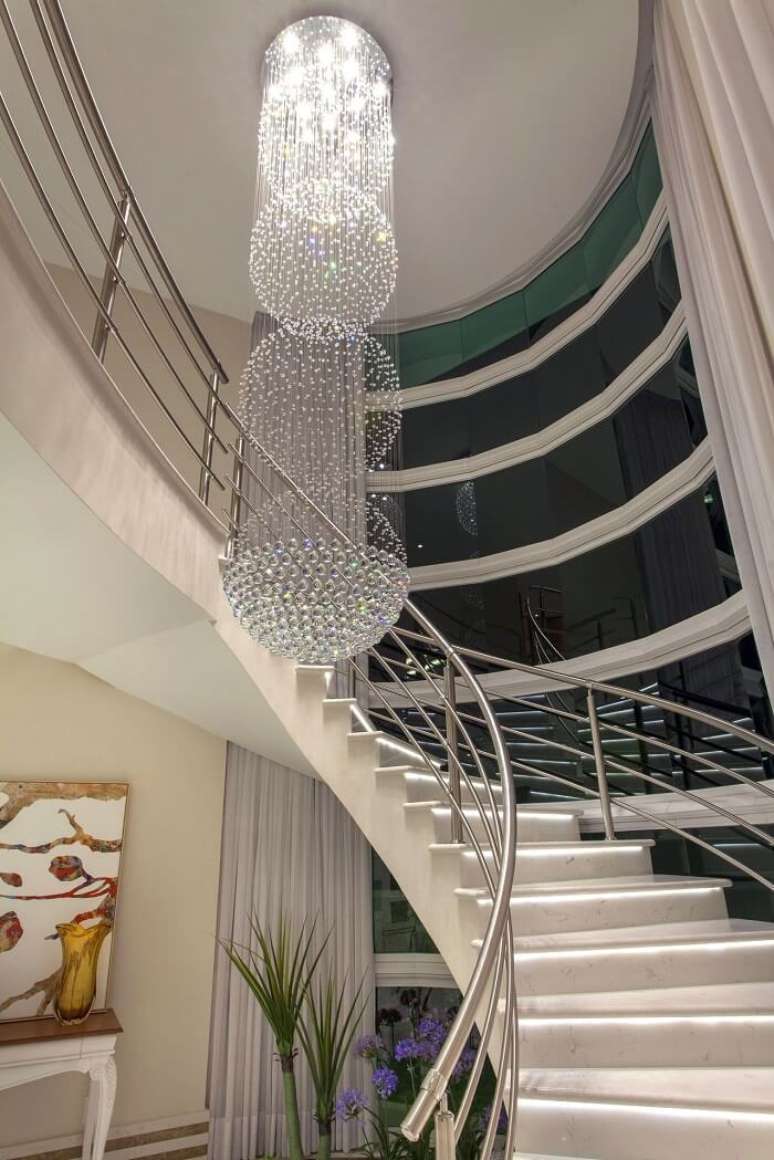 31. Lustre para escada p&eacute; direito alto repleto de cristais. Projeto de Iara Kilaris