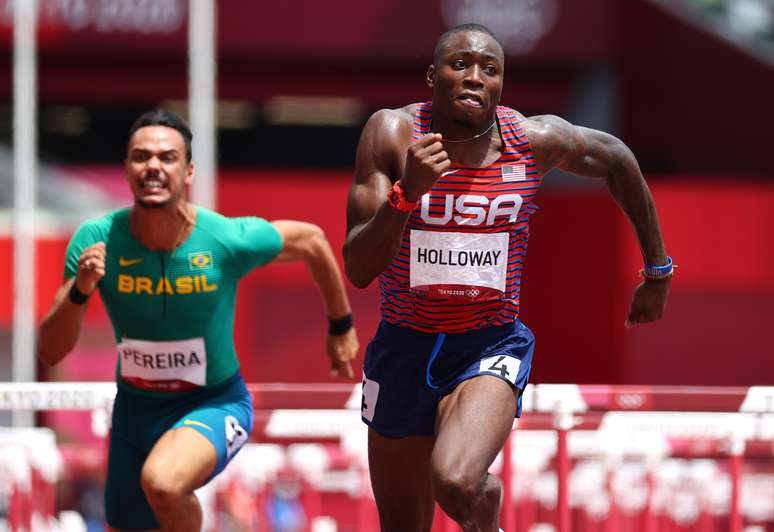 Com o brasileiro Rafael Pereira ao fundo, Grant Holloway corre para terminar semifinais na liderança