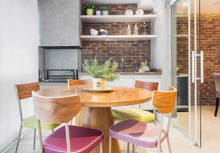 51. Mesa redonda para decoração de apartamento com varanda gourmet e churrasqueira – Foto: Pinterest