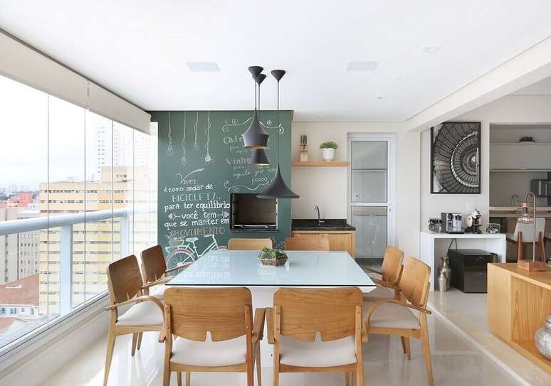 13. Apartamento com varanda gourmet decorado com mesa quadrada e tinta lousa – Foto: Renata Cafaro
