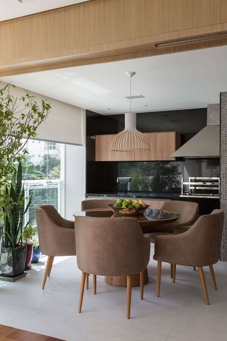 10. Apartamento com varanda gourmet decorada com mesa redonda e churrasqueira de vidro – Foto: Casa de Valentina