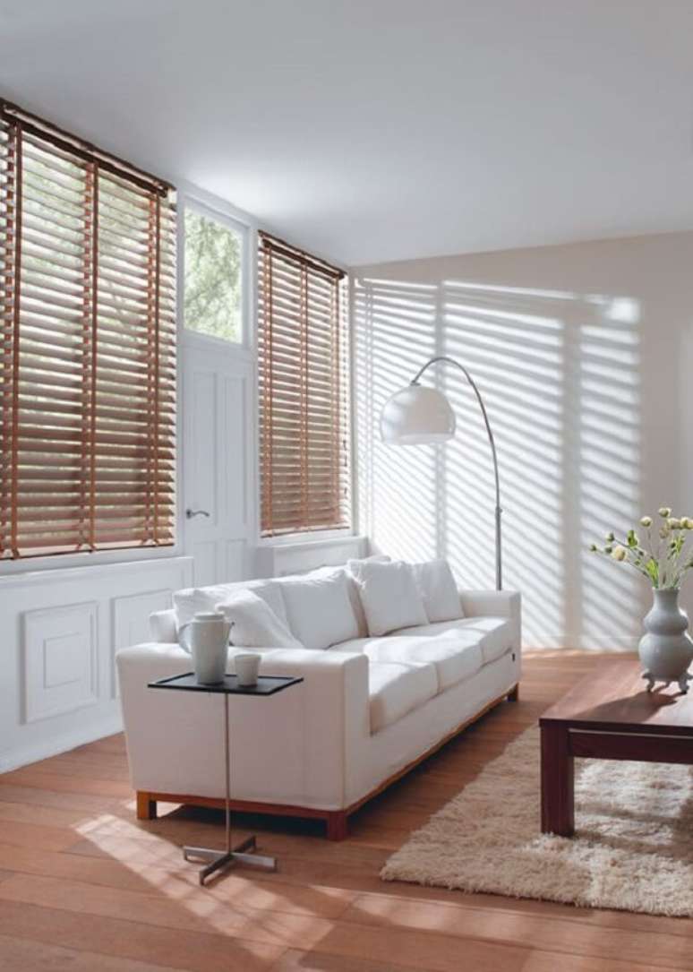 47. Sofá branco e persiana de madeira para sala decoram o espaço. Fonte: Pinterest