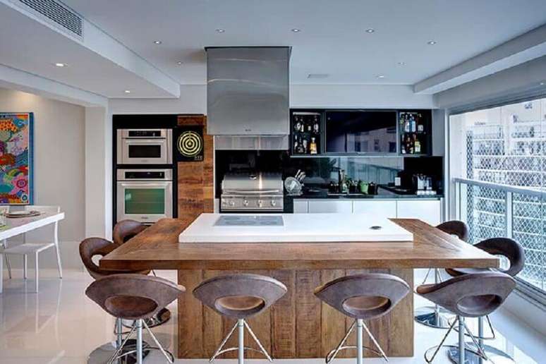 42. Ilha planejada com cooktop para decoração de apartamento com varanda gourmet moderna – Foto: Pinterest