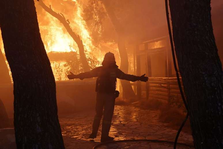 Bombeiro reage a incêndio florestal em subúrbio ao norte de Atenas
03/08/2021
REUTERS/Giorgos Moutafis