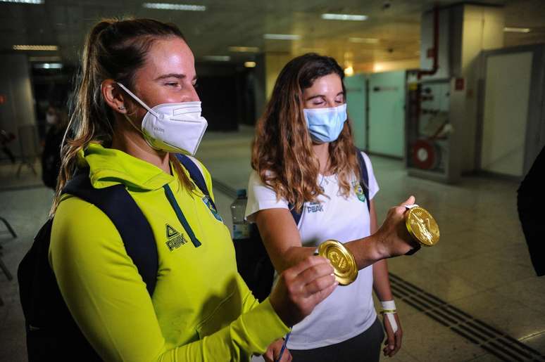 Velejadoras brasileiras exibem suas medalhas de ouro durante desembarque no País