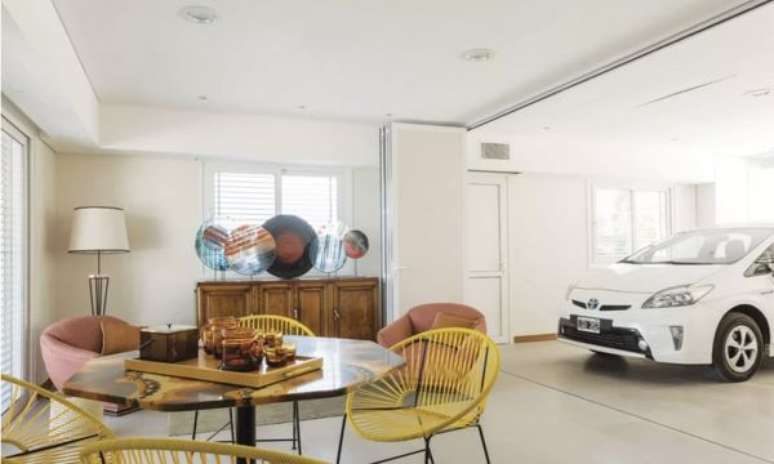 31. Cerâmica para garagem coberta em tons claros e mesa redonda para área de lazer – Foto Pinterest