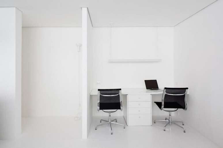 9. Escritório clean com cadeira preta e escrivaninha com gaveteiro branco. Projeto de Felipe Hess
