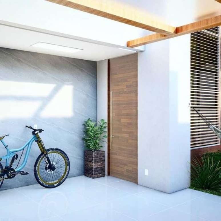 37. Cerâmica para garagem com portão de madeira moderno – Fonte Jordan Lima