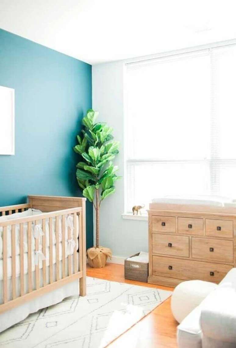 45. Parede azul para decoração de quarto para bebê simples com móveis de madeira – Foto: Casa de Valentina