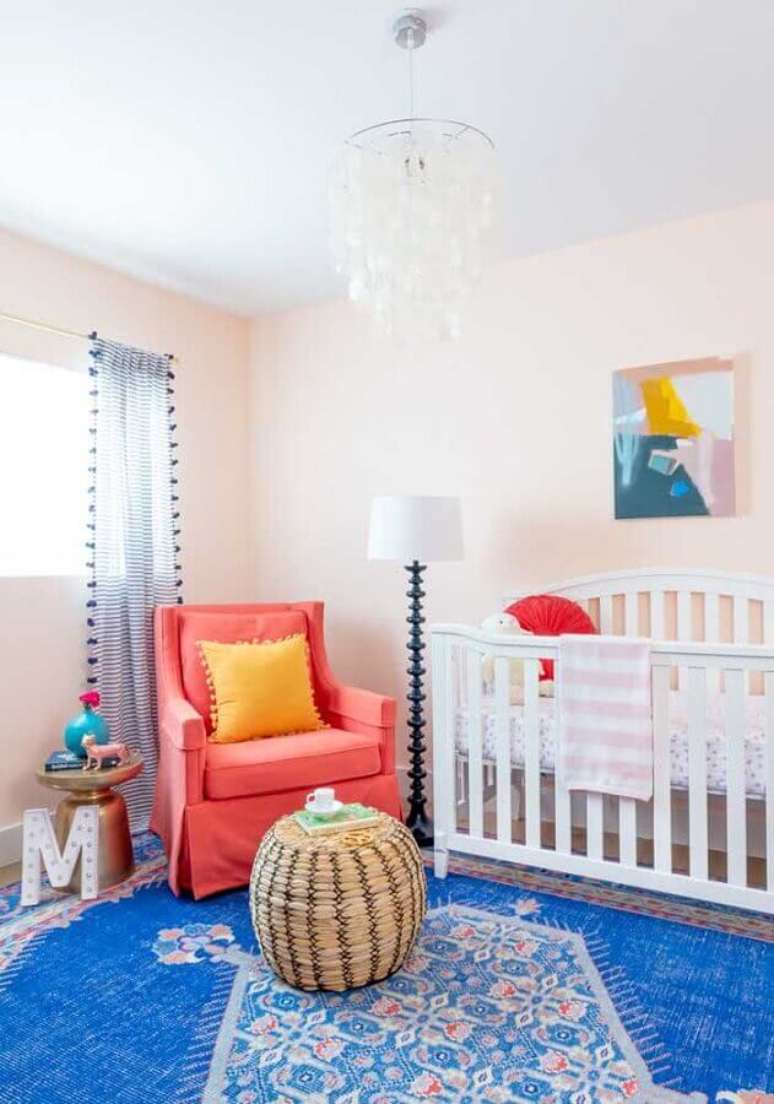 5. Decoração simples de quarto para bebê com tapete azul e poltrona rosa – Foto: Pinterest