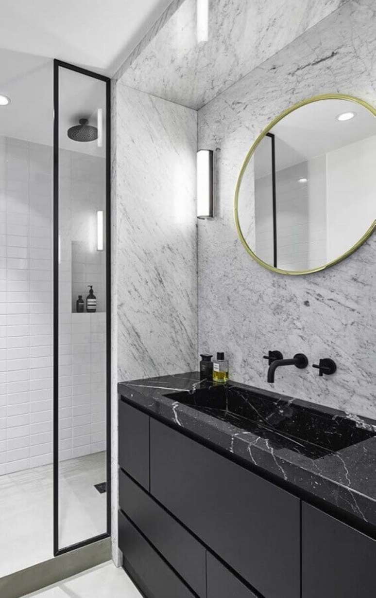 18. Banheiro sofisticado decorado com espelho redondo e bancada de mármore preto – Foto Behance