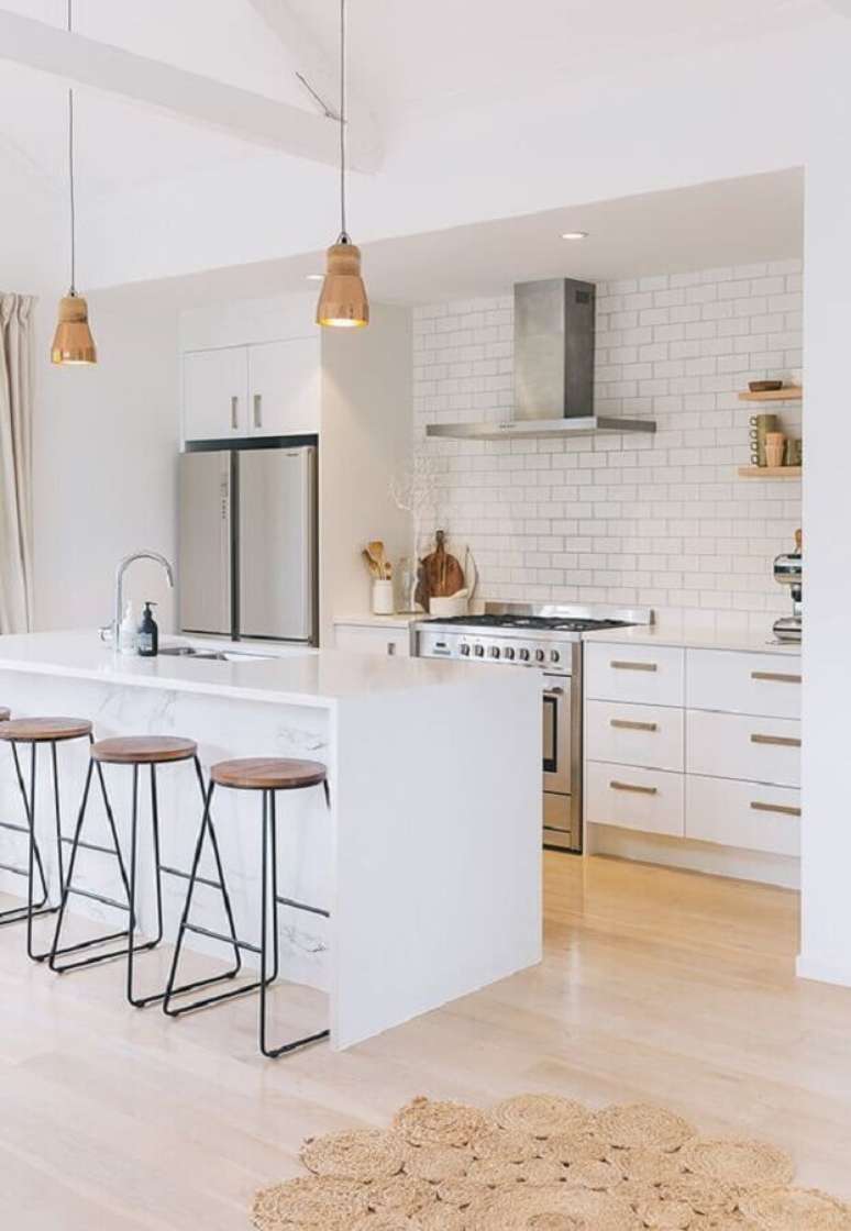 36. Decoração com armários brancos e ilha de cozinha com banqueta minimalista – Foto: Apartment Therapy