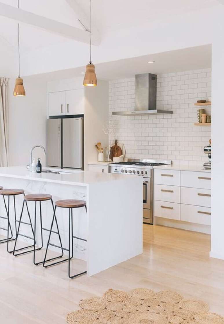36. Decora&ccedil;&atilde;o com arm&aacute;rios brancos e ilha de cozinha com banqueta minimalista &ndash; Foto: Apartment Therapy