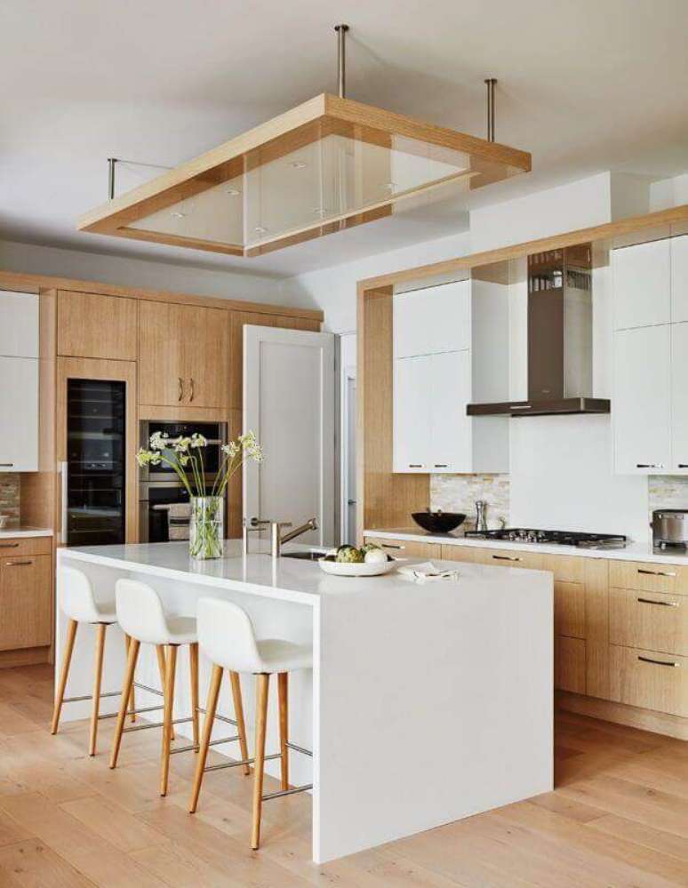23. Cozinha branca com madeira decorada com banqueta alta para ilha – Foto: House & Home