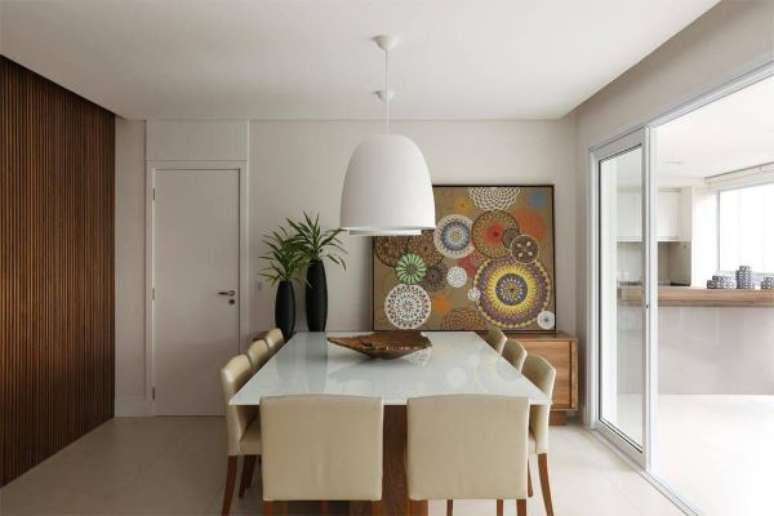 38. Mesa de jantar quadrada branca com cadeira bege e quadros geométricos – Foto Revista VD