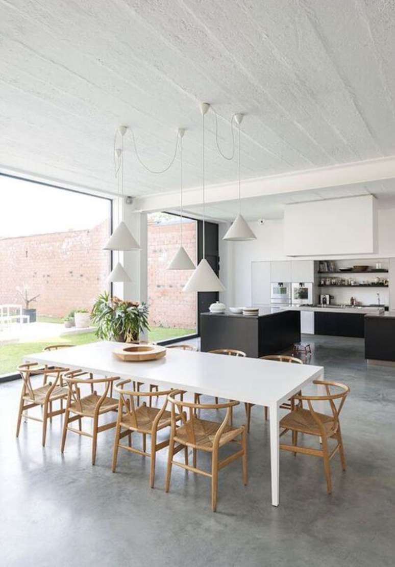 1. Mesa de jantar branca para varanda gourmet clean com piso de cimento queimado e cadeiras de madeira – Foto El Hombre