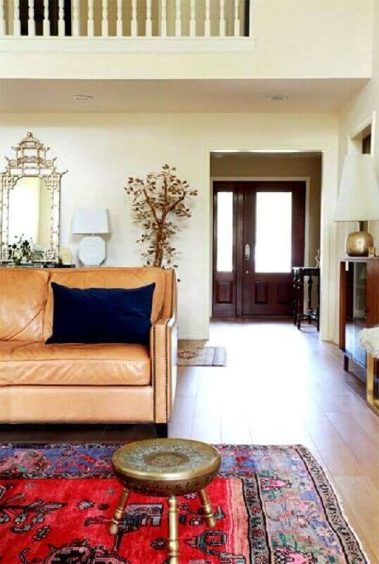 47. Sala simples decorada com sofá cor caramelo e tapete vermelho – Foto: Jeito de Casa