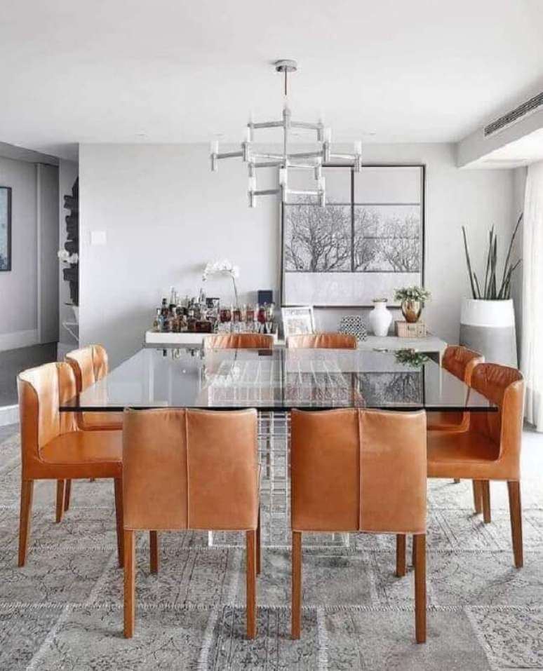 12. Cadeira cor caramelo para sala de jantar moderna decorada com mesa de vidro quadrado – Foto: Histórias de Casa