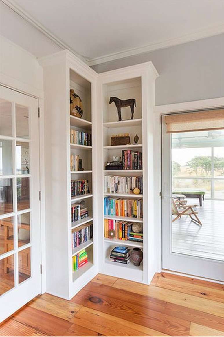 31. Estante de canto para livros na sala de estar com abertura para varanda gourmet – Foto Homedit