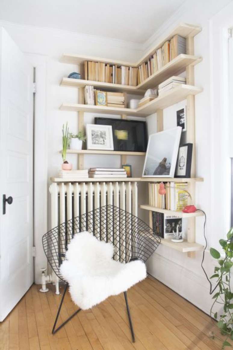 30. Estante de canto planejada com cadeira moderna perto – Foto Pinterest