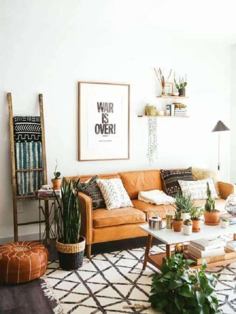 25. Decoração simples para sala branca com sofá cor caramelo e vasos de plantas – Foto: Archzine