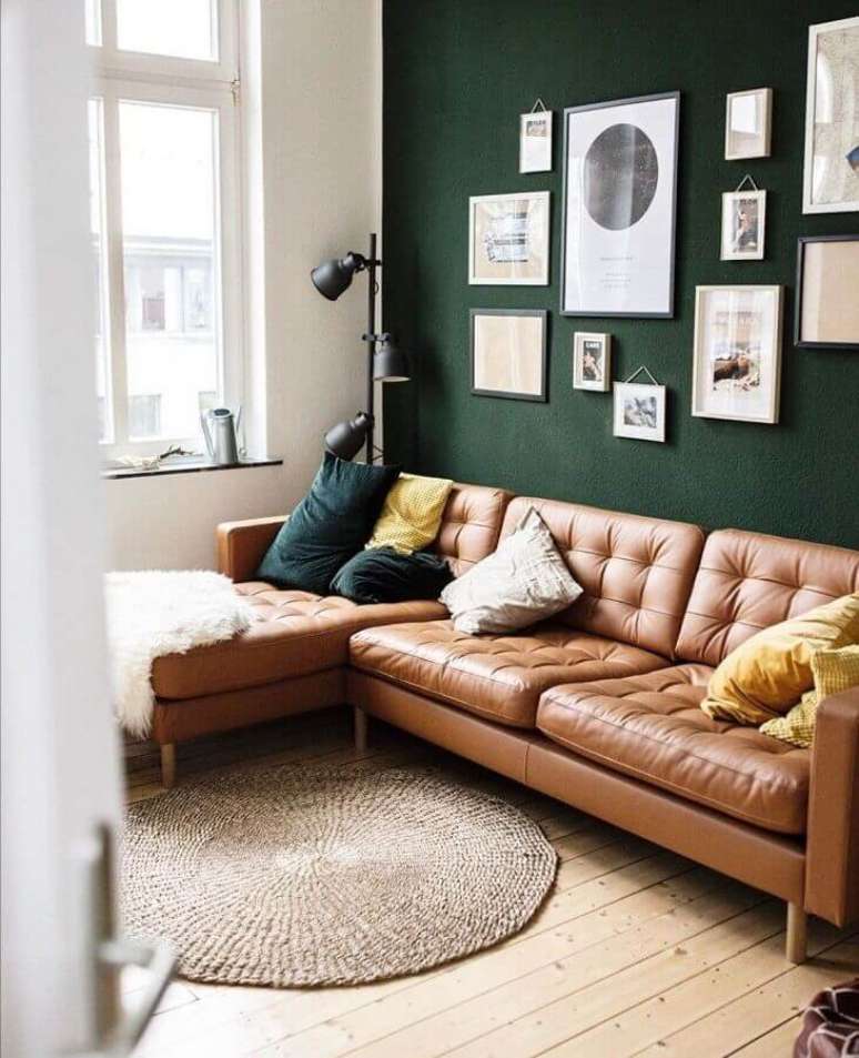 52. Sofá cor caramelo para decoração de sala com parede verde escura – Foto: Archilovers