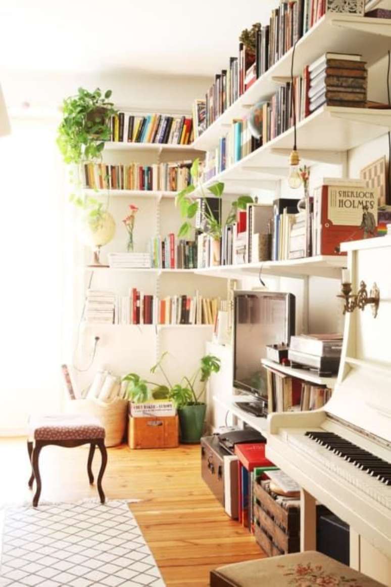 55. Sala de TV com estante de canto, tv e piano branco – Foto Musicnotes