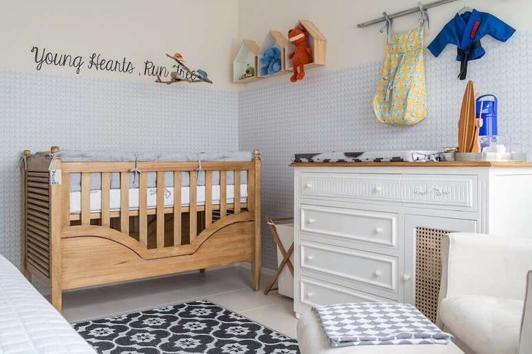 30. Cômoda de bebê branca para decoração de quarto com papel de parede 3D e berço de madeira – Foto: NaToca Design