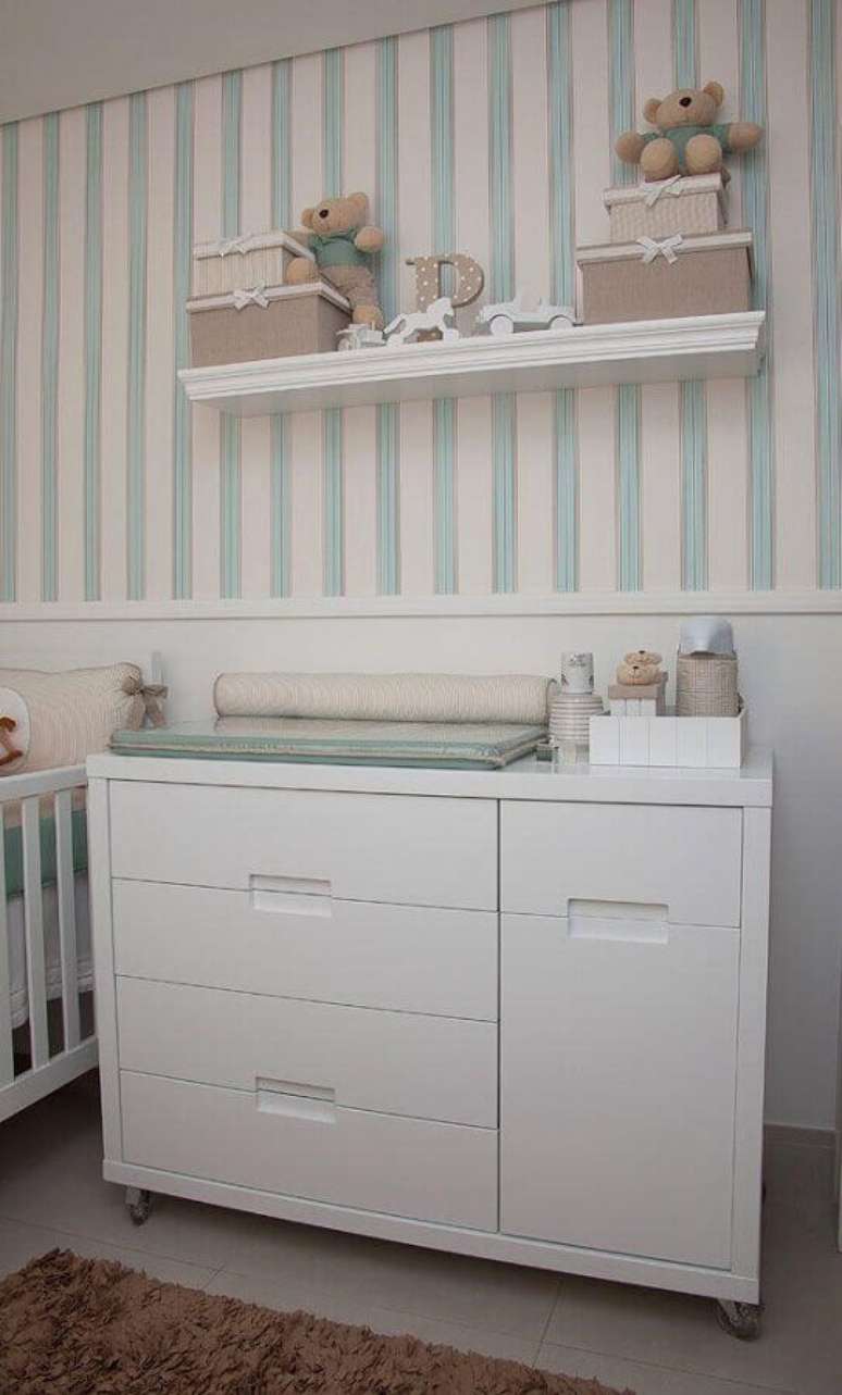 32. Cômoda de bebê branca para quarto decorado com papel de parede listrado – Foto: Pinterest