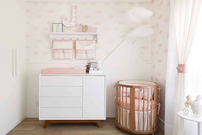 9. Quarto de bebê feminino decorado com papel de parede delicado e cômoda branca pequena – Foto: Pinterest