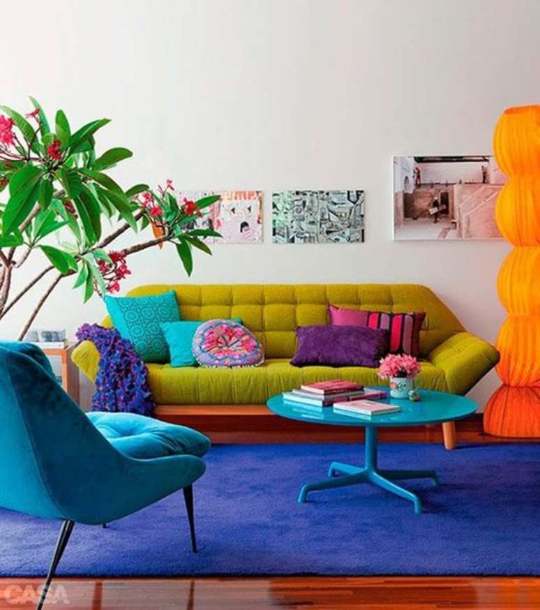 3. Sala retrô colorida com sofá pé palito verde e poltrona azul na mesma cor que o tapete – Foto casa cor