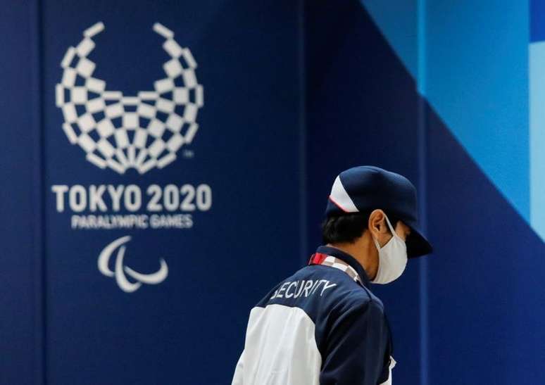 Segurança usando máscara de proteção passa em frente o alogo dos Jogos Parlímpicos Tóquio 2020 em Tóquio
16/08/2021 REUTERS/Issei Kato